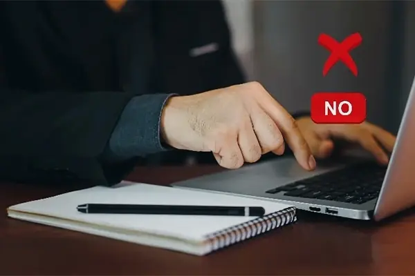 A person pointing at a laptop screen with a red'NO' symbol, illustrating prohibited activities on Webpundits' Encoding RDP plans. emphasizes the importance of adhering to Webpundits' guidelines to ensure a safe and reliable server experience, disallowing activities such as hacking, VPN usage, OBS streaming, DDoS tools, and other illegal activities.